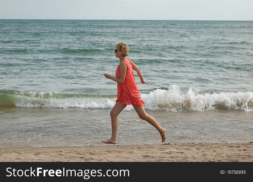 Young Woman Running On The Beach