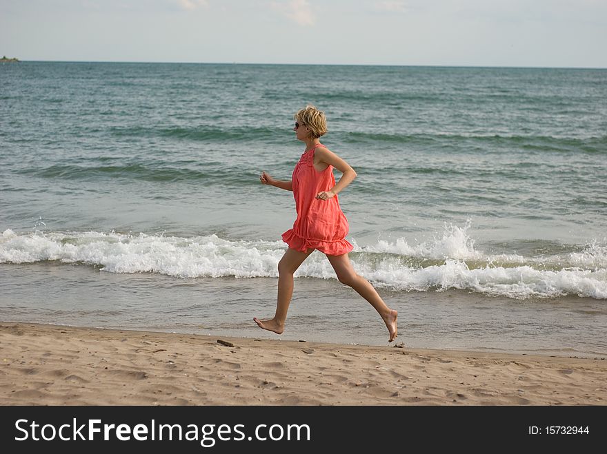 Young Woman Running On The Beach