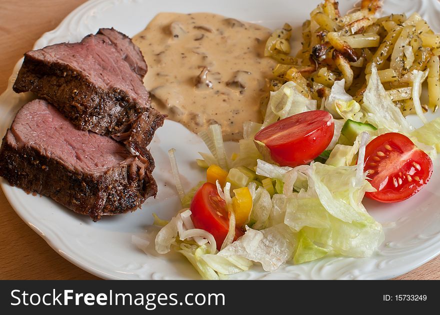 Cuts of tenderloin with sauce and tomatoes