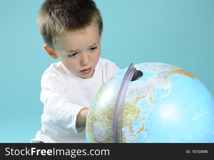 Photography with caucasian preschooler searching locations on globe. Photography with caucasian preschooler searching locations on globe