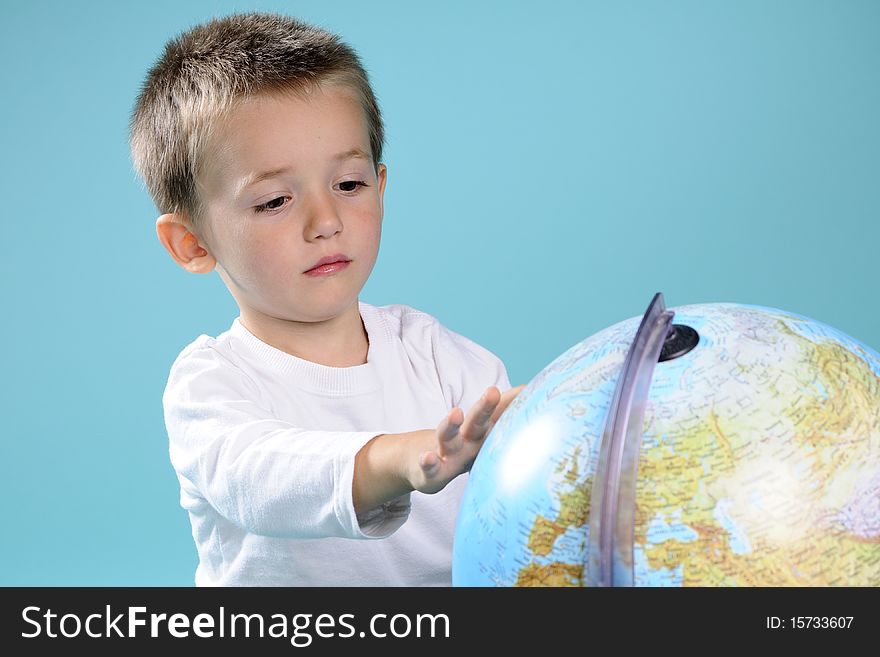 Photography with caucasian preschooler searching locations on globe. Photography with caucasian preschooler searching locations on globe
