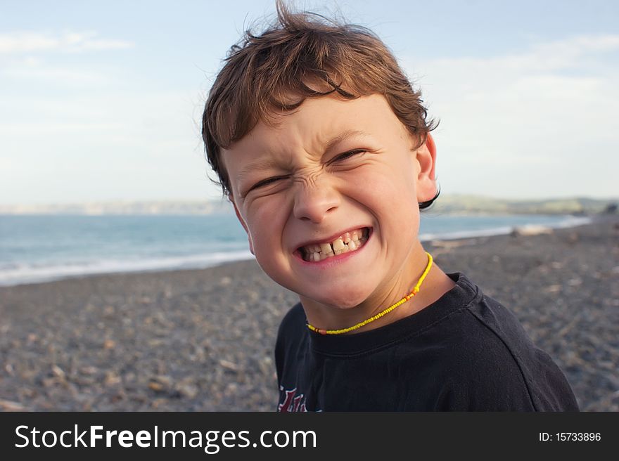 A young male grimaces while at the beach. A young male grimaces while at the beach