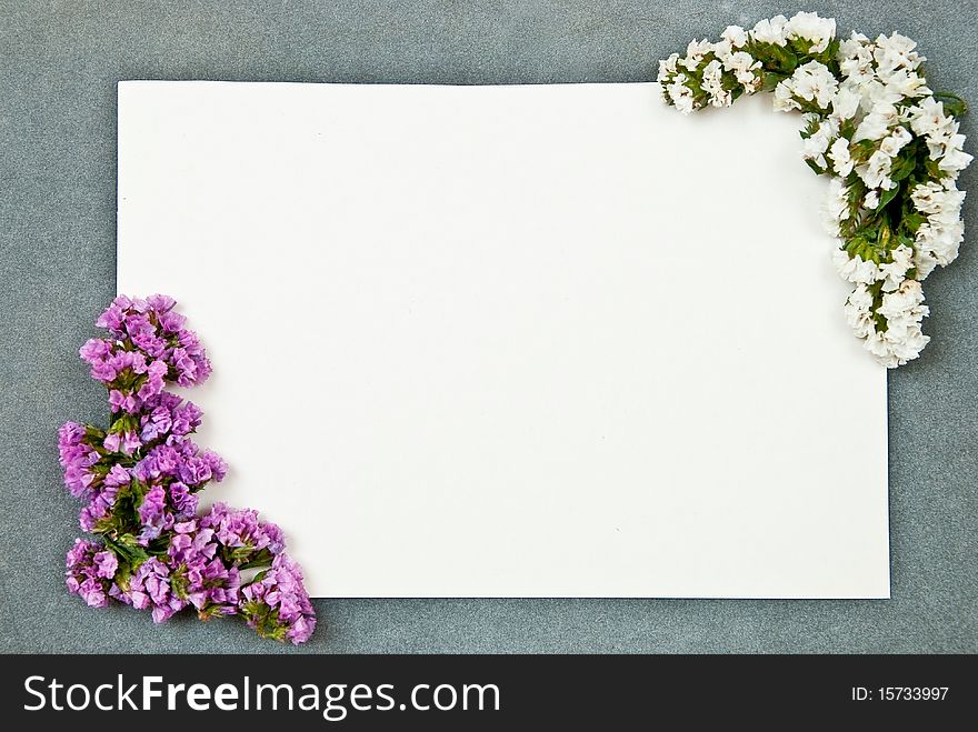 Green paper blank on grey background. With flowers. Green paper blank on grey background. With flowers