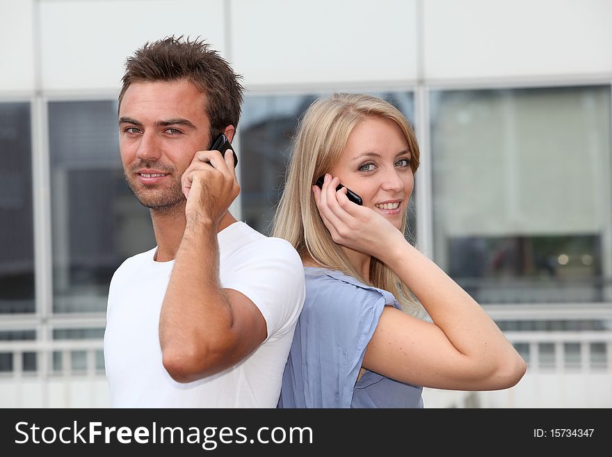 Couple standing outside with mobile phone. Couple standing outside with mobile phone