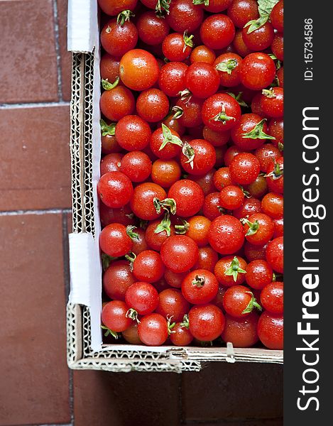 A lot of organic red cherry tomatoes in a basket