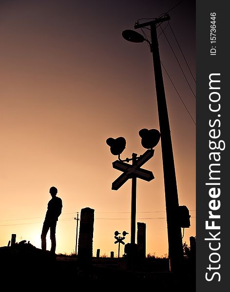 Silhouette of young man standing at summer sunset crossroad. Silhouette of young man standing at summer sunset crossroad