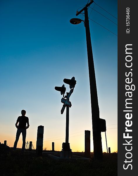 Silhouette of a man standing at summer crossroads sunset. Silhouette of a man standing at summer crossroads sunset