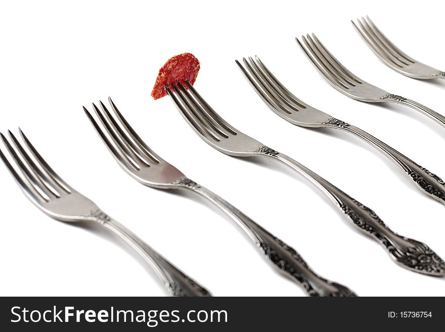 Forks and piece of sausage isolated on white background