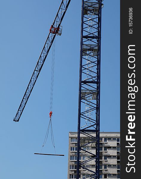 Steel crane at building site on the blue sky