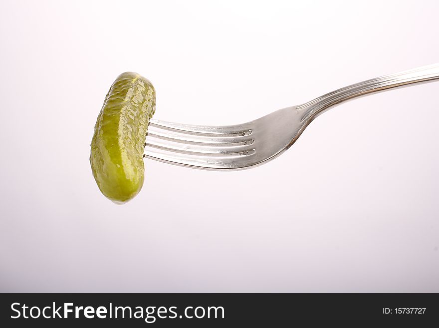 Marinated cucumber on fork (close up, clipping path)