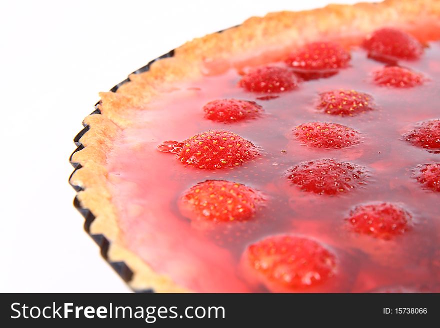 Strawberry Tart in a tart pan on a white background in close up