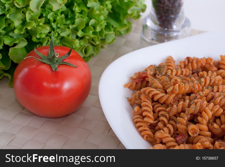 Bowl of macaroni with tomato and salad