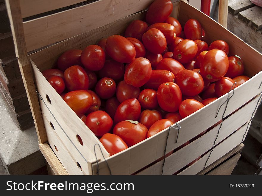 Basket filled with ripe, red tomatoes on farmer's vegetable stand. Basket filled with ripe, red tomatoes on farmer's vegetable stand