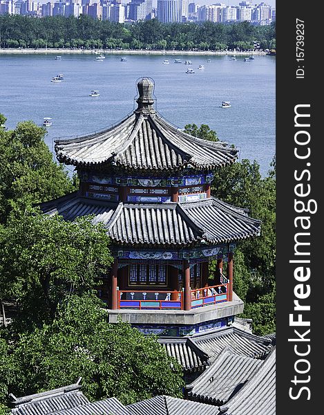 A traditional Chinese pavilion by Kunming Lake in Summer Palace, with modern buildings in the distance. A traditional Chinese pavilion by Kunming Lake in Summer Palace, with modern buildings in the distance.