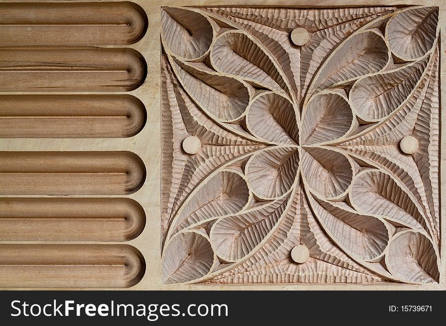 View of an Intricately carved wood panel, characterized by large and small sweeping curves and inspired by European medieval patterns.