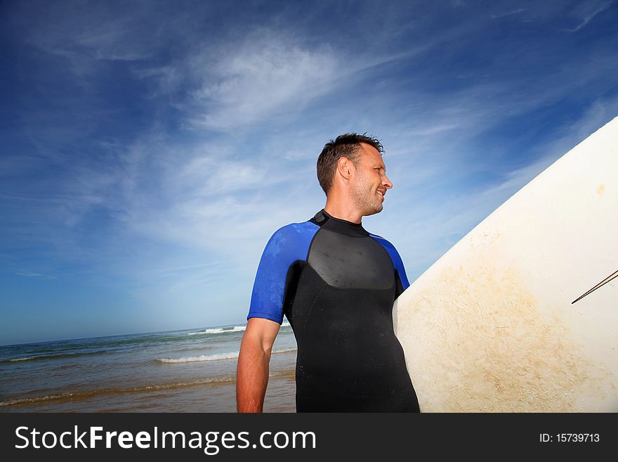 Man holding surfboard at the beach. Man holding surfboard at the beach