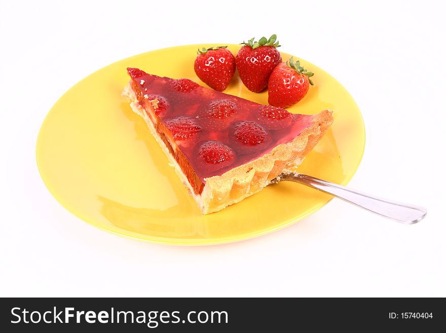 Piece of Strawberry Tart being put on a yellow plate decorated with strawberries with a cake server