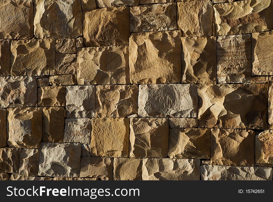 Light falling on a stone wall, showing texture.