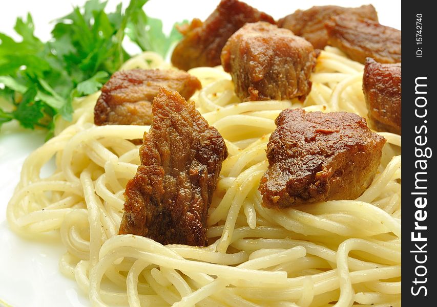 Spaghetti with meat and greens on a white background. Spaghetti with meat and greens on a white background