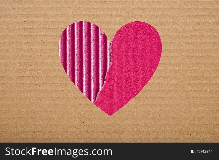 Pink paper hole in brown cardboard background