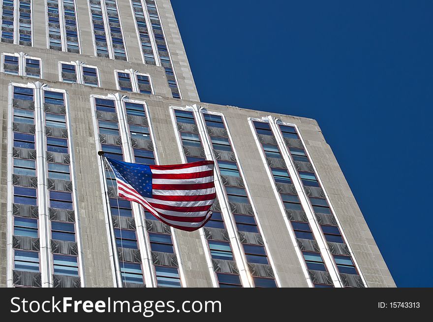 American flag contrasting with a blue sky and building. American flag contrasting with a blue sky and building.