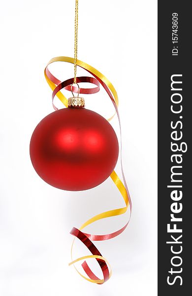 Hanging red glass ball with the ribbons on the white background