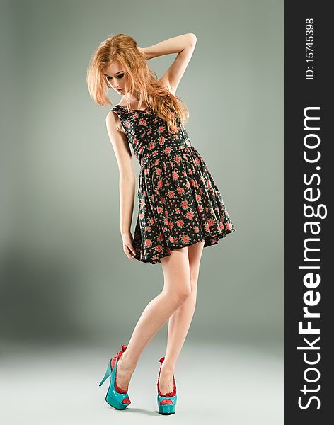 Beautiful red-haired girl on grey background/ Studio shot