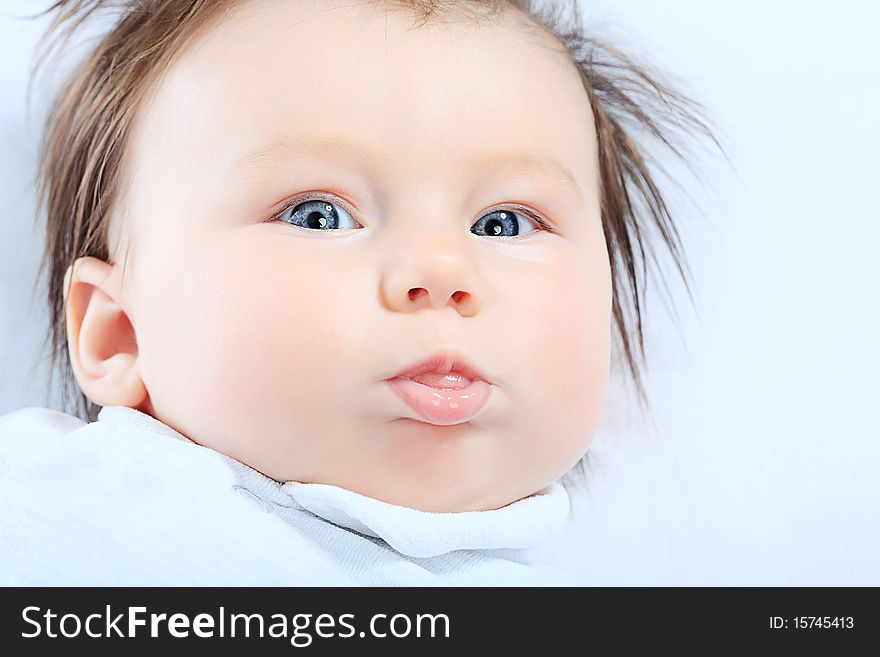 Portrait of a cute baby lying on a white towel. Portrait of a cute baby lying on a white towel.