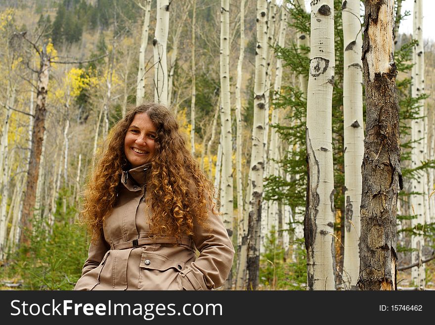 Laughing girl between trees in forest. Laughing girl between trees in forest