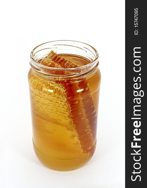 Glass jar full of honey with honeycomb, isolated on white. Glass jar full of honey with honeycomb, isolated on white