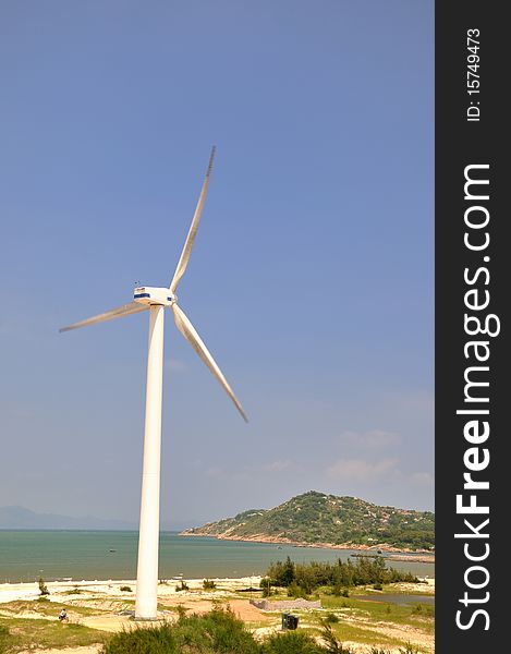 Wind power generator in wide area by sea, under blue sky. Wind power generator in wide area by sea, under blue sky.