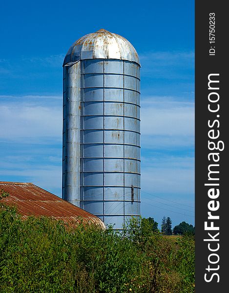 Silo with barn and blue sky