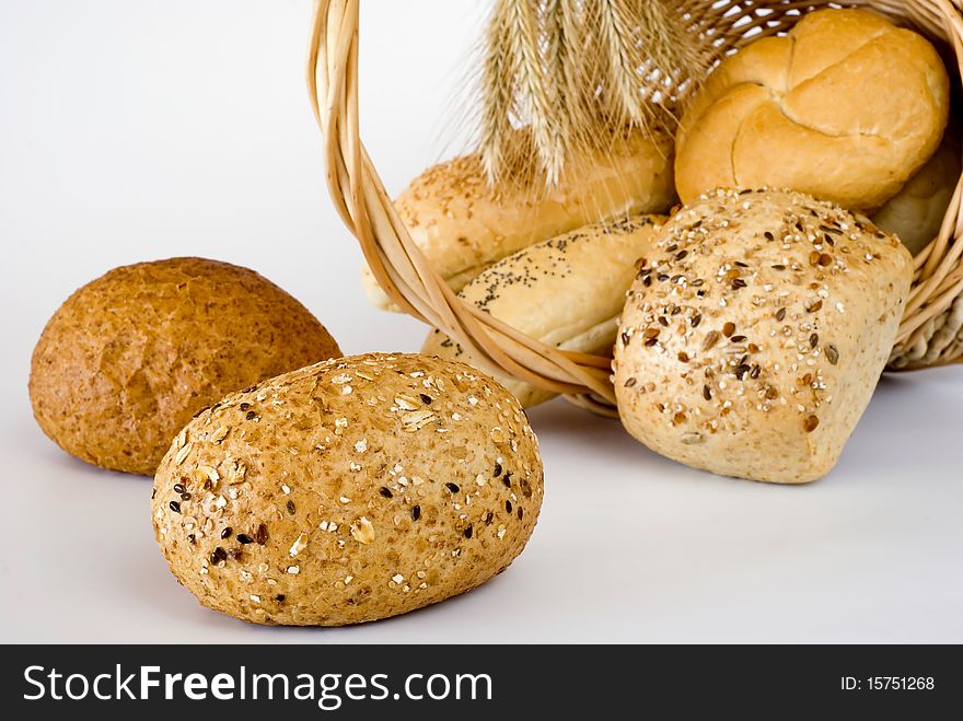 Basket turned over with the fresh bread on the white background. Basket turned over with the fresh bread on the white background