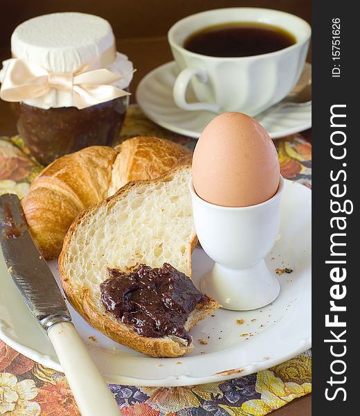 Croissant, egg, chocolate cream and cup of coffee for breakfast