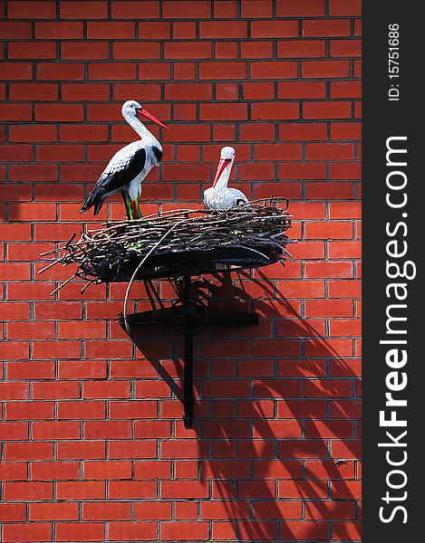 Nest of storks on a brick house wall. Nest of storks on a brick house wall