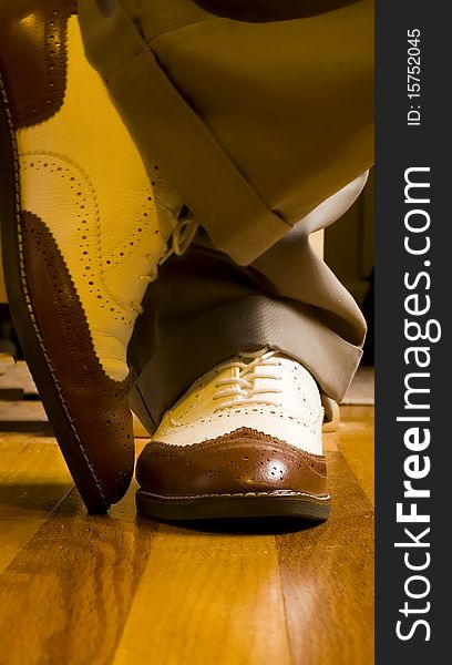 Close up of Men's brown and white dance shoes on oak floor. Close up of Men's brown and white dance shoes on oak floor