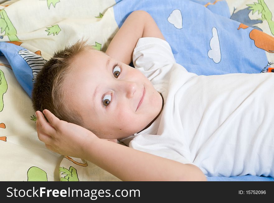 Little cute boy lying down on the bed