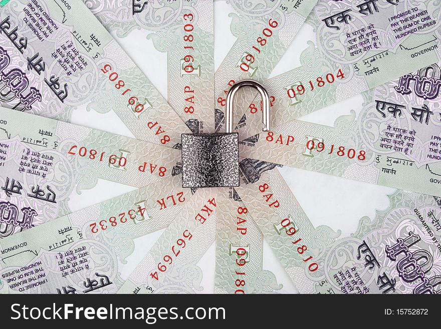 Open lock reflecting no security on Indian currency 100 rupee notes in a circular manner. Open lock reflecting no security on Indian currency 100 rupee notes in a circular manner