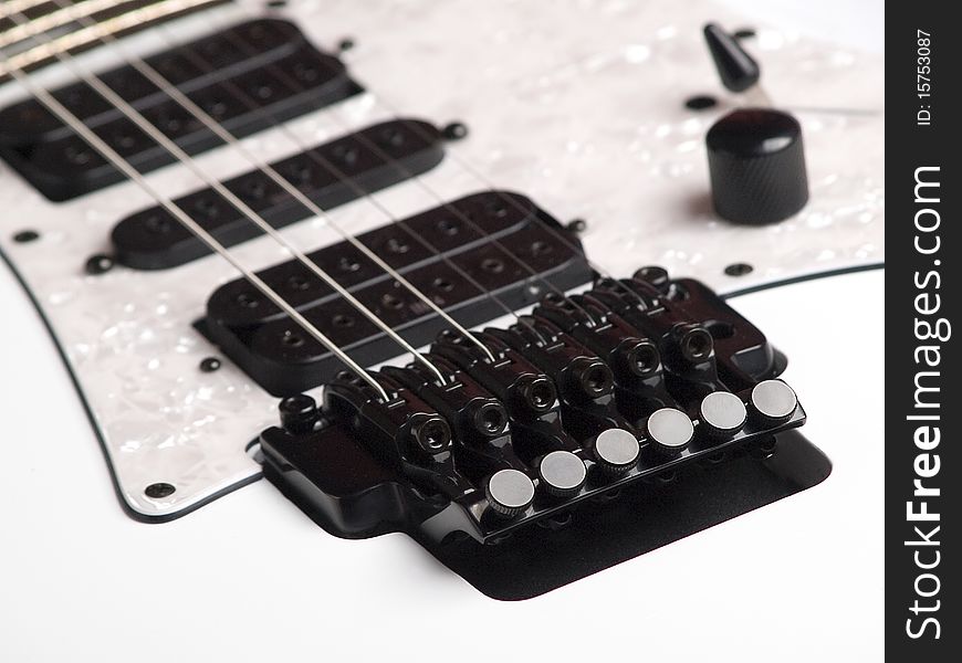 The picture shows a part of a white e-guitar. The picture shows a part of a white e-guitar