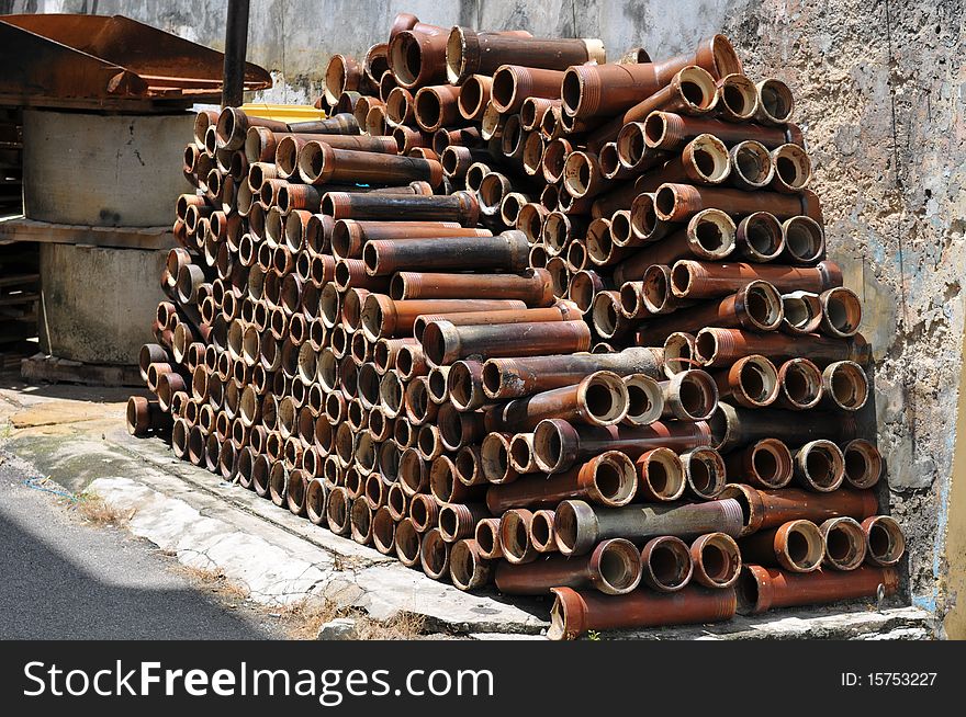 Pile of pipes on side of road=