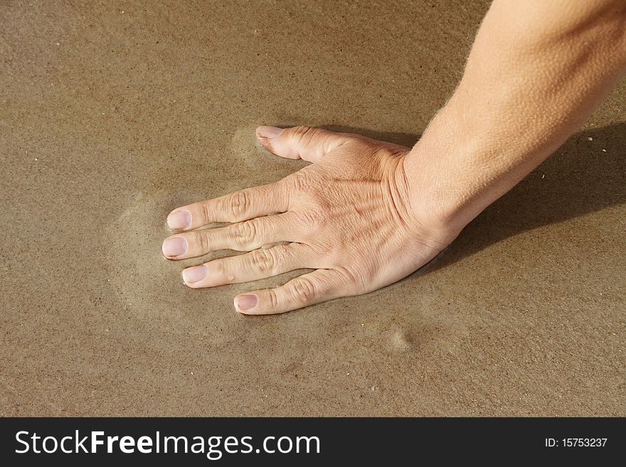 Human hand on beach sand. Human hand on beach sand.