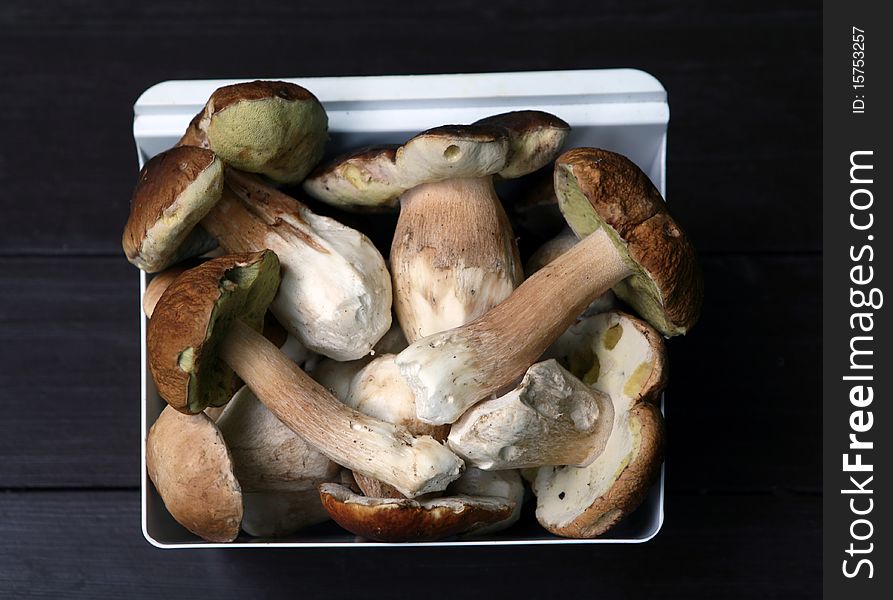 Various wild mushrooms in bowl on the wooden table. Various wild mushrooms in bowl on the wooden table