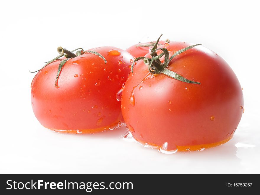 Three ripe tomatoes in water over white
