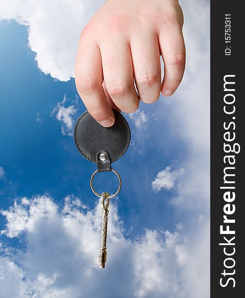 Retro key in hand on blue sky background