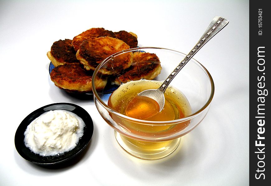 Honey and cheese bowl with a spoon of honey and cheese pancakes on a plate