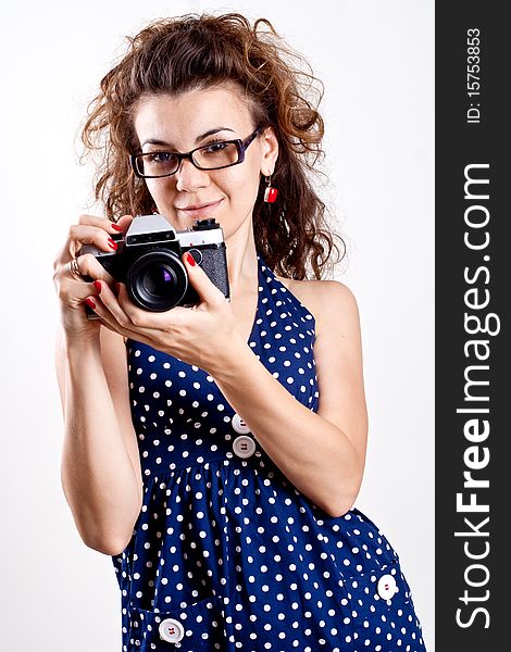 Beautiful woman in a blue polka dot dress with camera