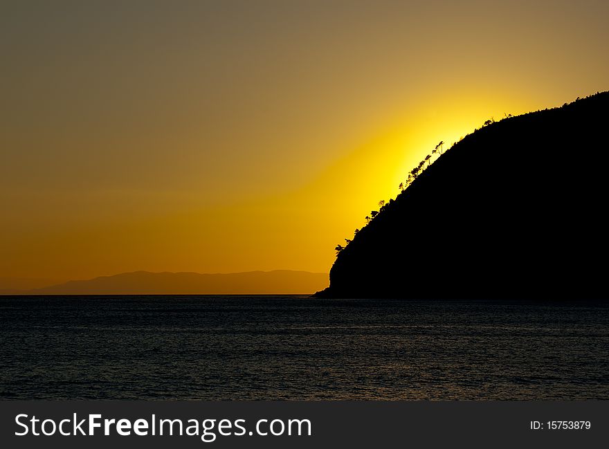 An orange and yellow sunset over a calm sea. An orange and yellow sunset over a calm sea