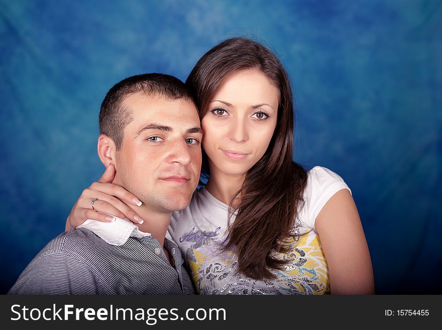 Woman and man posing together on a blue background. Woman and man posing together on a blue background