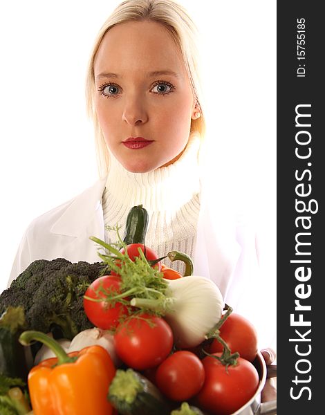 Young blond woman holding some different fresh vegetables. Young blond woman holding some different fresh vegetables