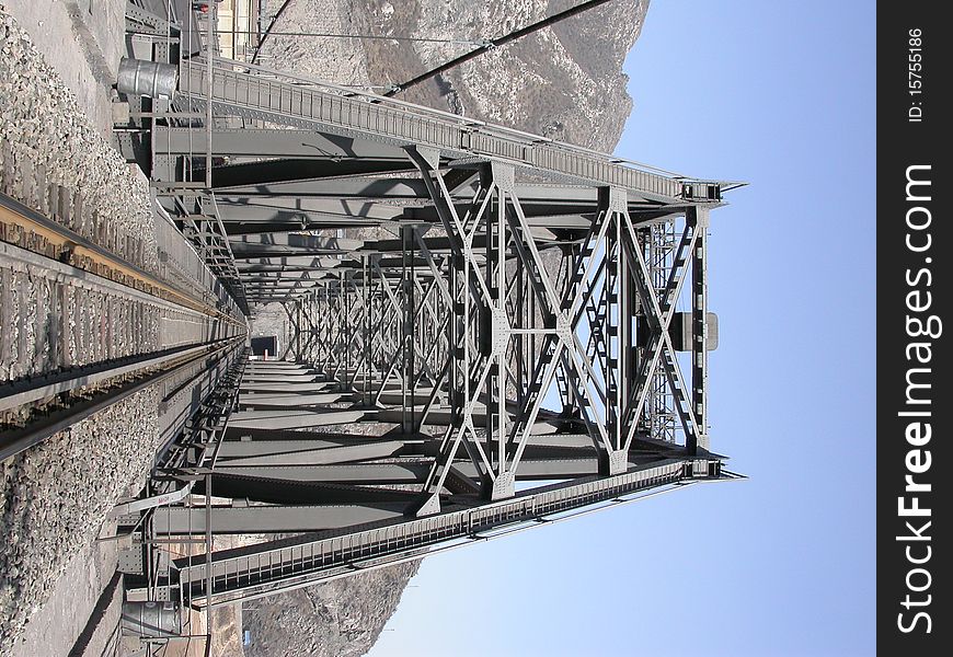 Steel railway bridge into tunnel in the moutain